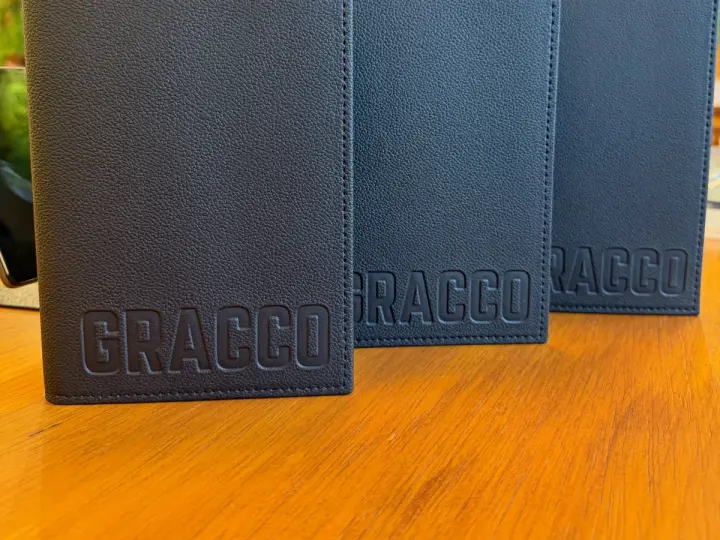 Três porta-comandas de couro com a marca GRACCO gravada em baixo-relevo