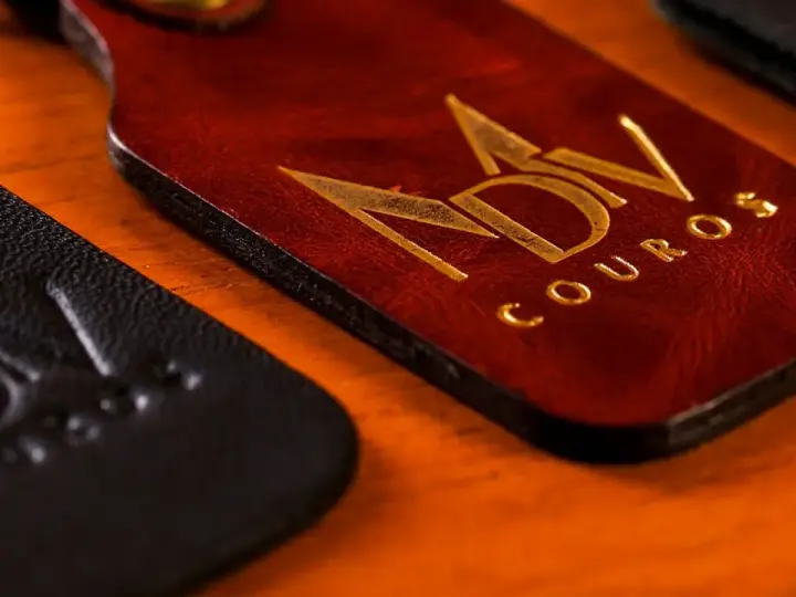 Chaveiro de couro caramelo com o logo da MDV aplicado em dourado