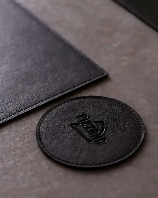 Post: porta-copo redondo de couro preto com logo gravado
