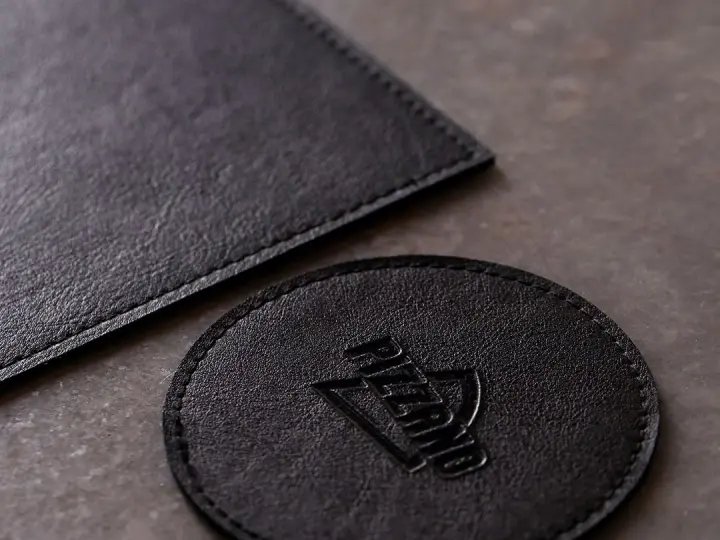Porta-copo redondo de couro preto com logo gravado